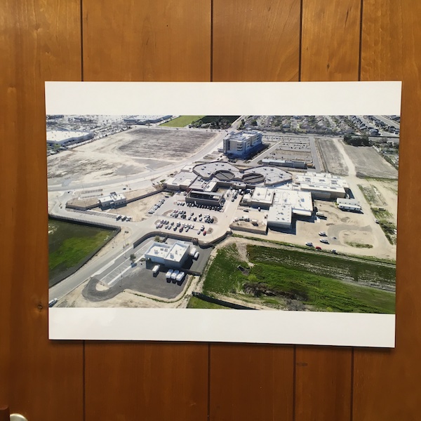 picture of jail buildings hanging on wood paneled office wall 